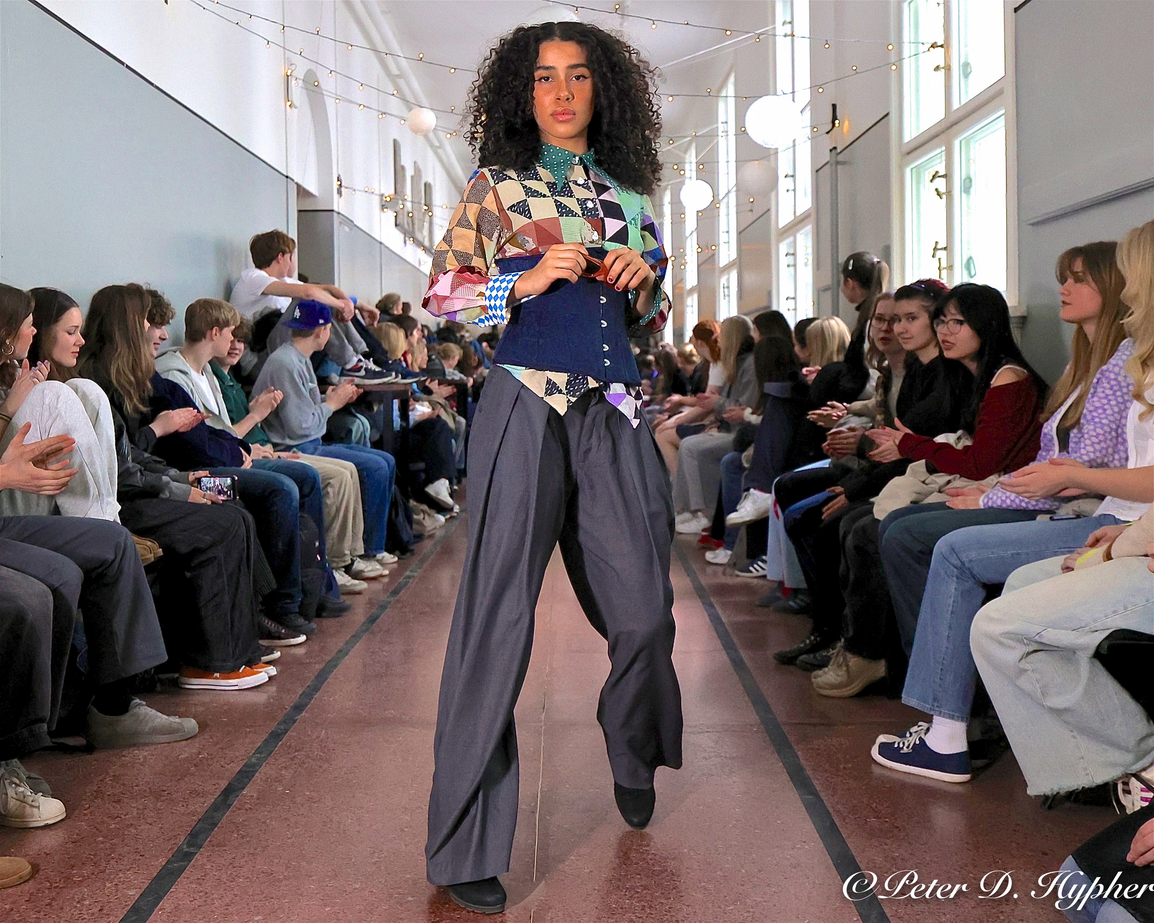 en person i et plagg som går foran en mengde mennesker