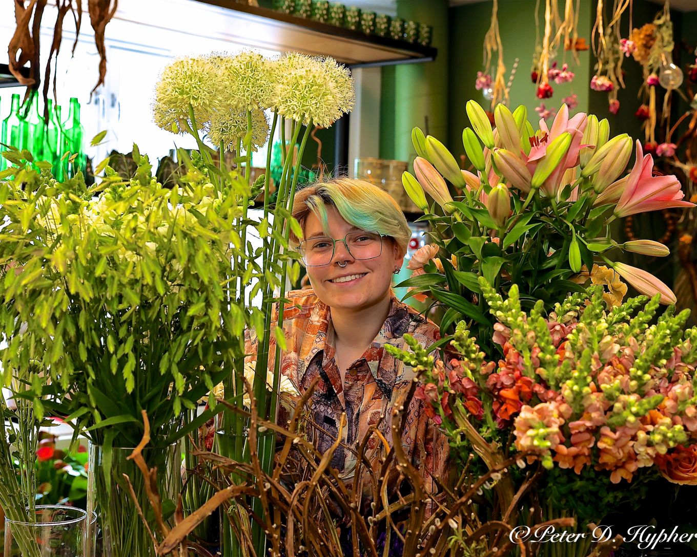 en person som står foran en blomsterhage en person som står foran en blomsterhage