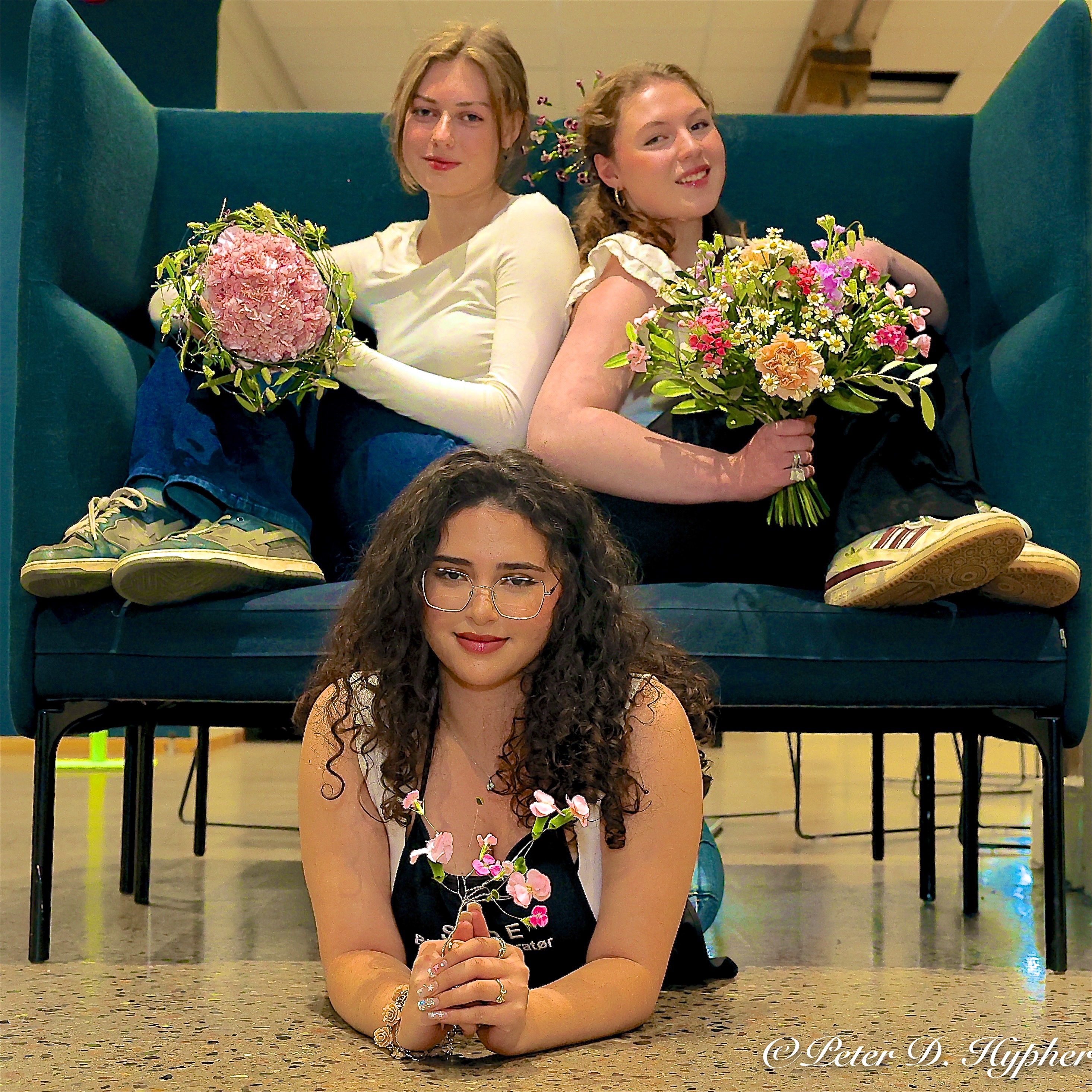 En gruppe personr som sitter i en sofa og holder blomster