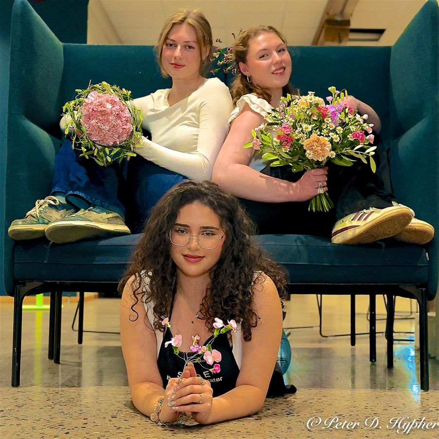 En gruppe personr som sitter i en sofa og holder blomster En gruppe personr som sitter i en sofa og holder blomster