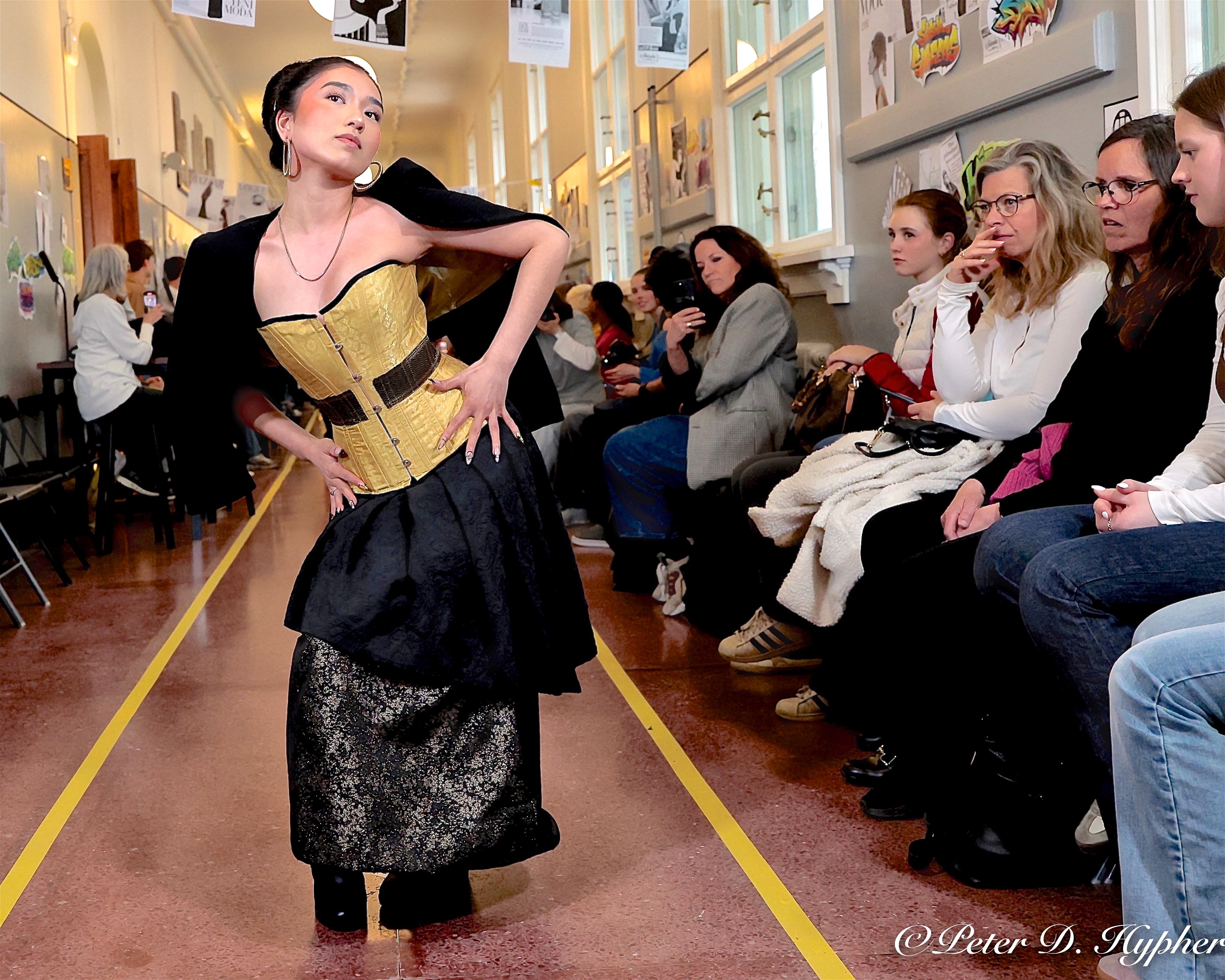 en person i kjole som står foran en gruppe mennesker