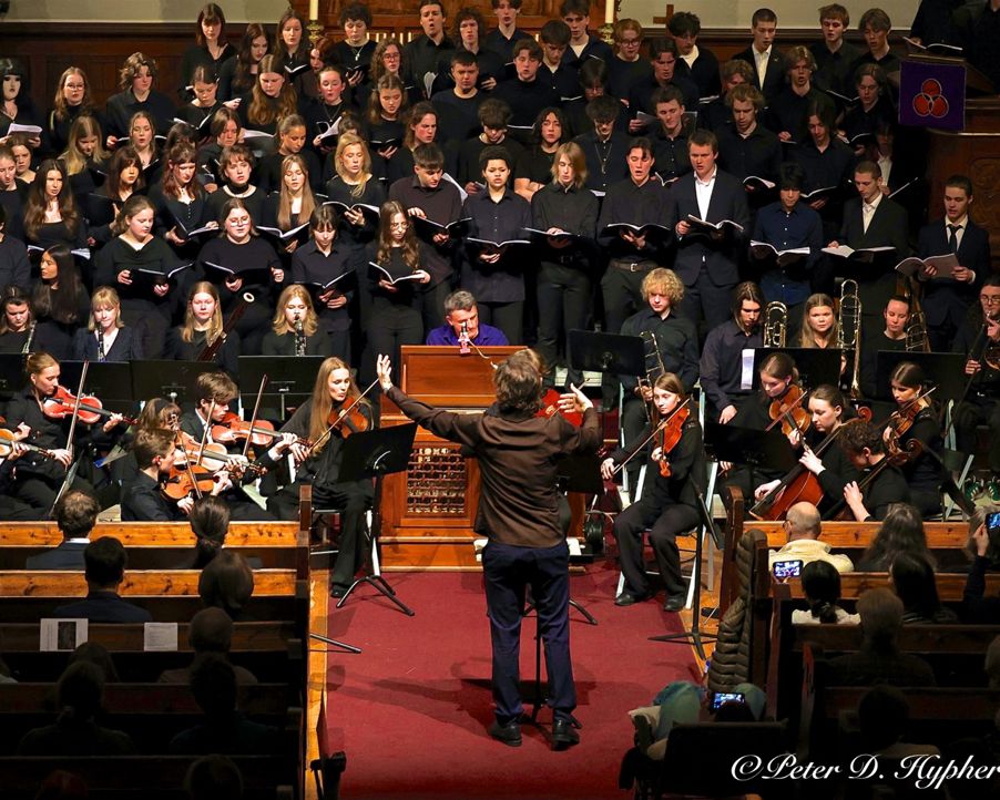 en person som går på en rød løper foran et orkester