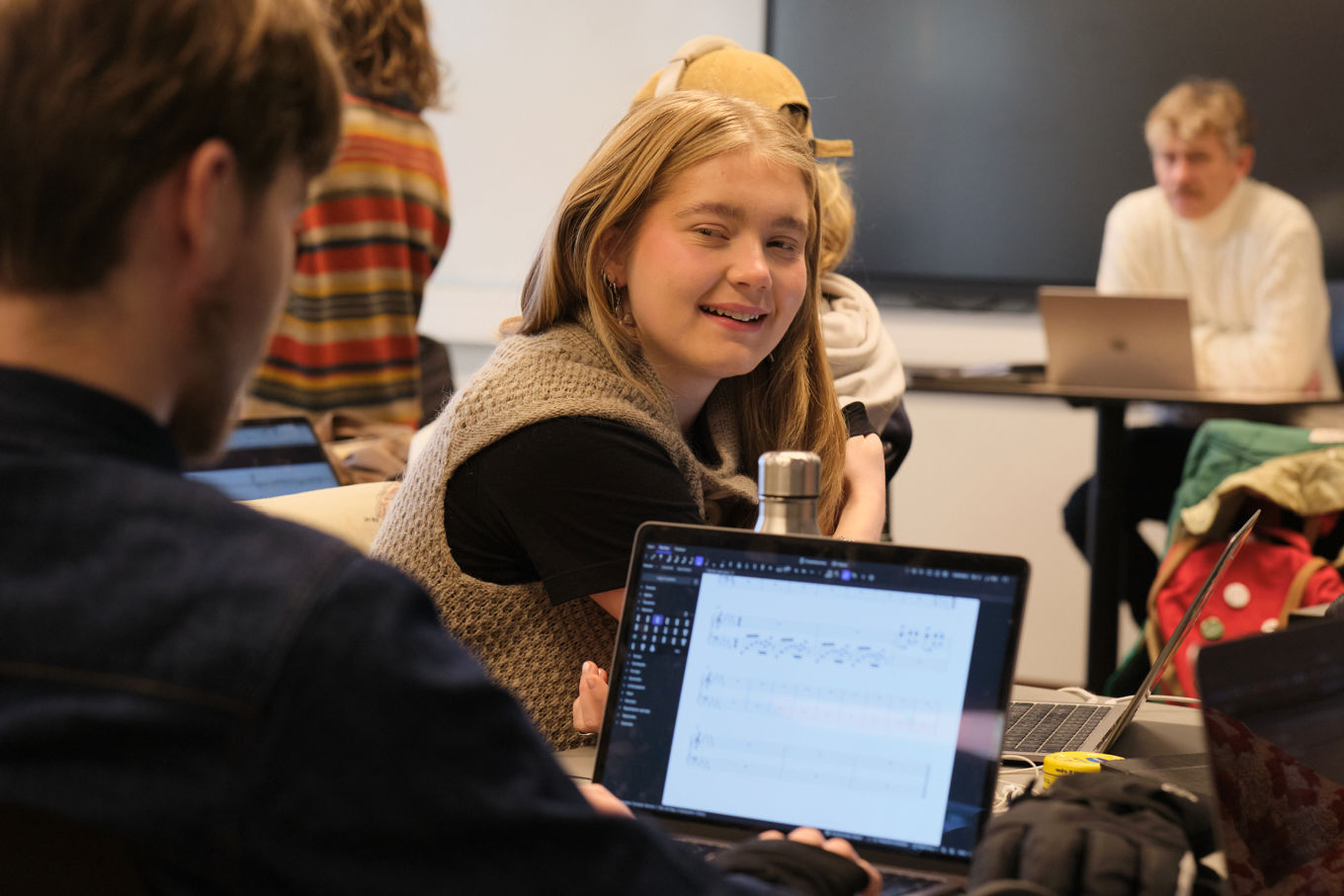 en person som viser en person noe på laptopen