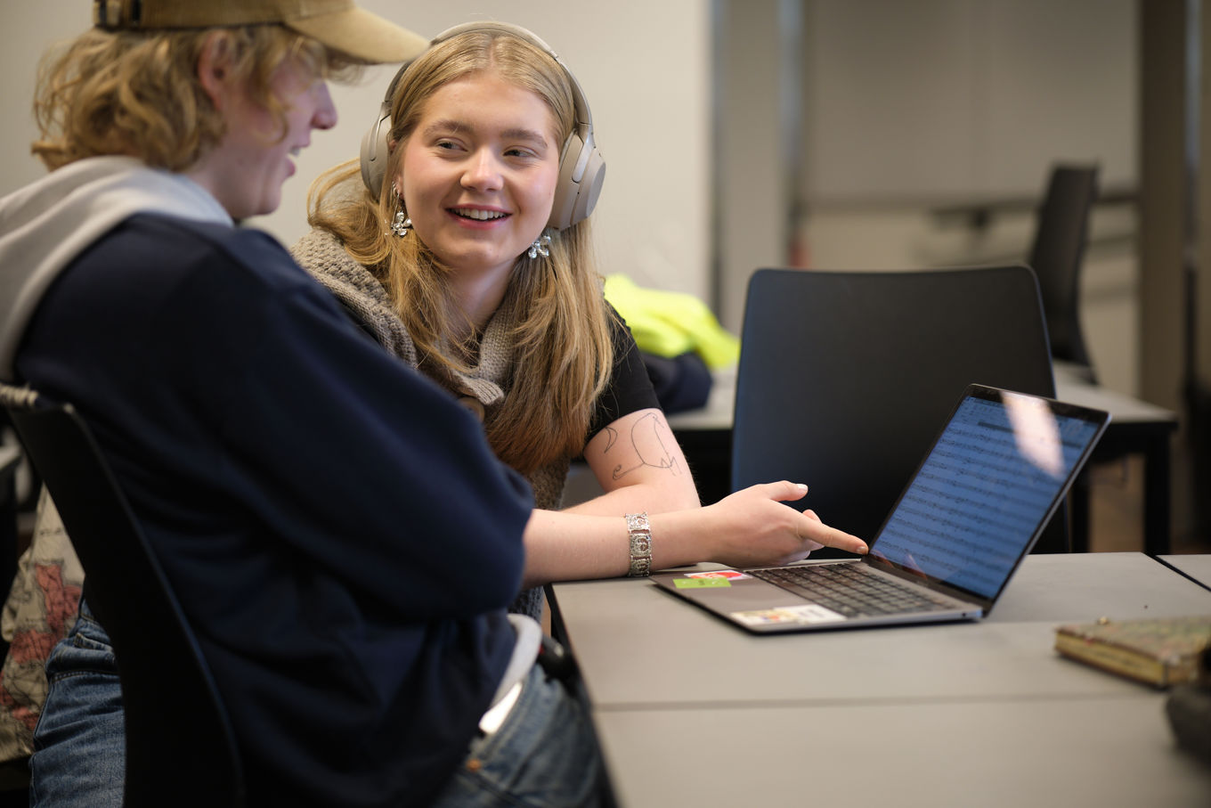 En person med hodetelefoner og som bruker laptop