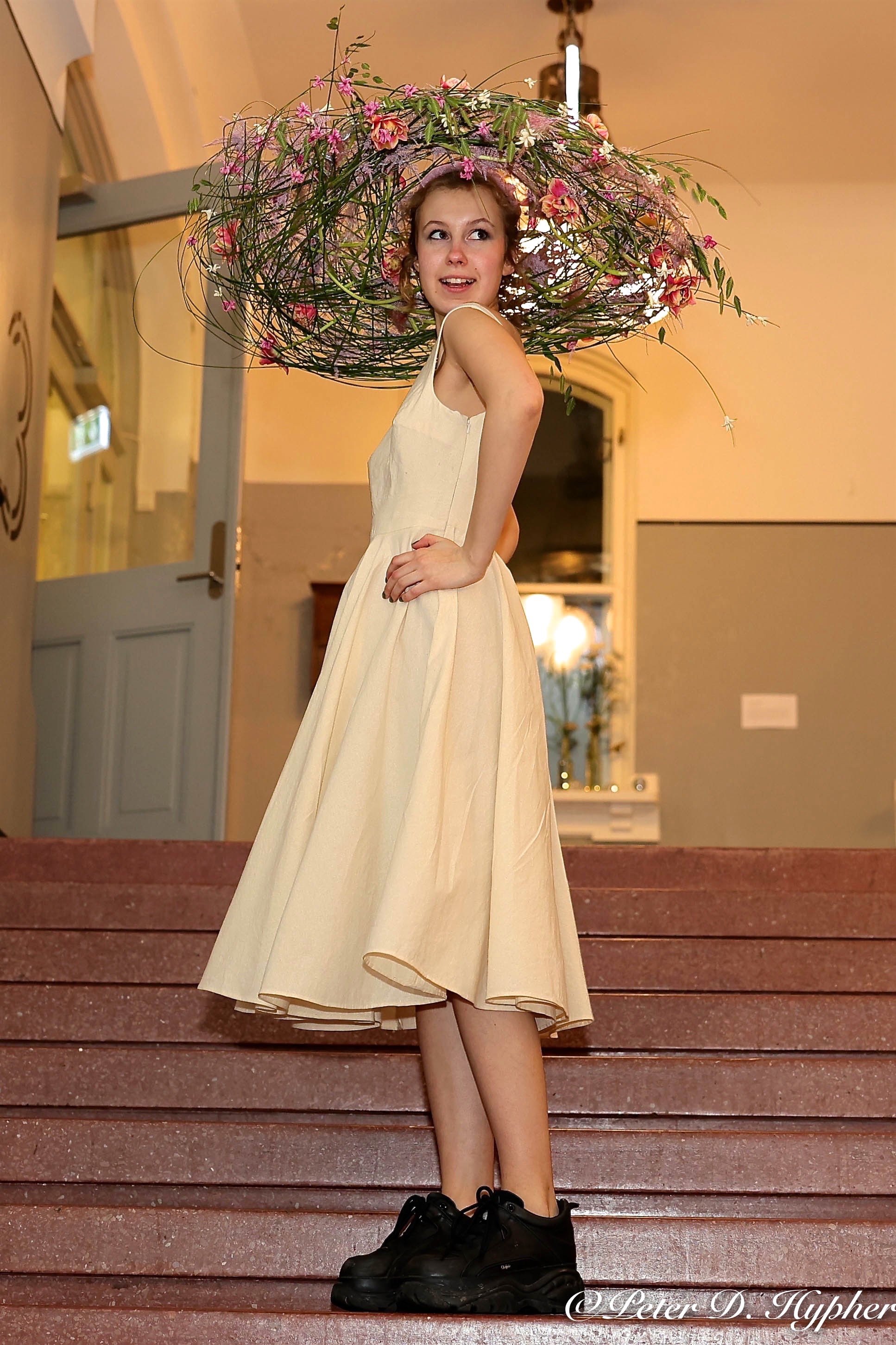 en person iført en hvit kjole og en blomsterkrone