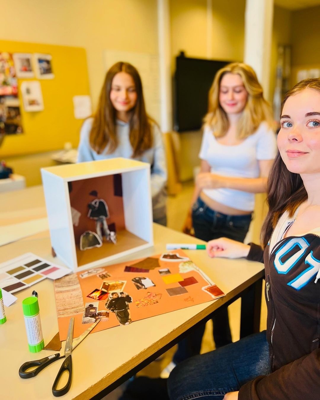 en gruppe personr som sitter ved et bord med en datamaskin