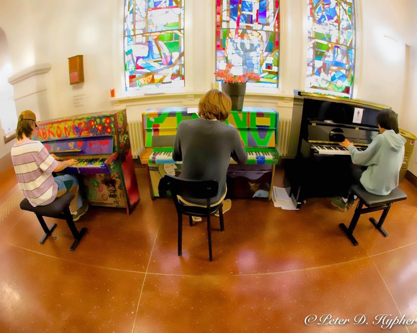 tre elever spiller piano