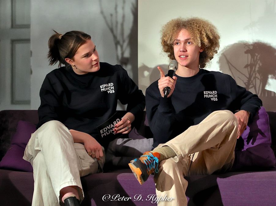 et par personr som sitter på en sofa med en mikrofon