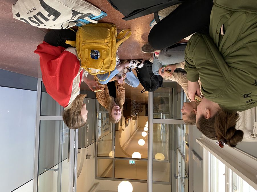 en gruppe personr som sitter på gulvet