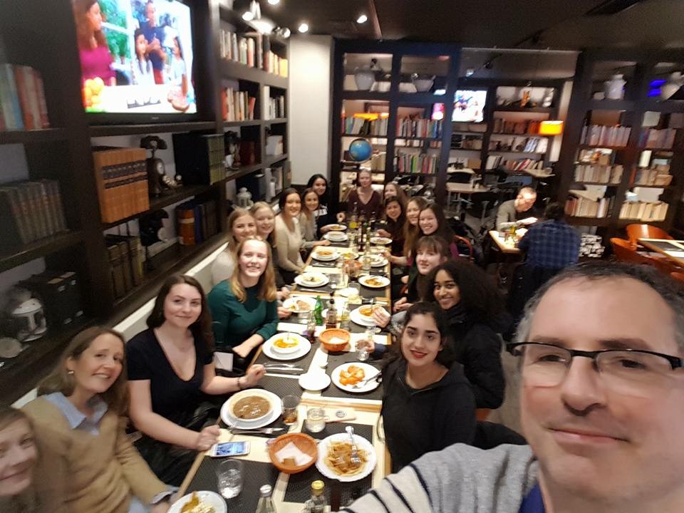 en gruppe mennesker som sitter ved et bord med mat