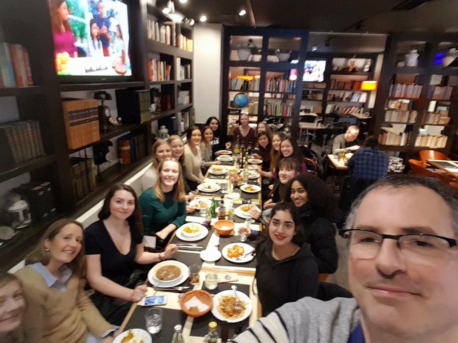 en gruppe mennesker som sitter ved et bord med mat